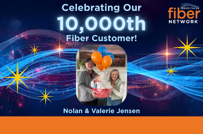 Photo of couple with gift basket and balloons with Idaho Falls Fiber text on balloon